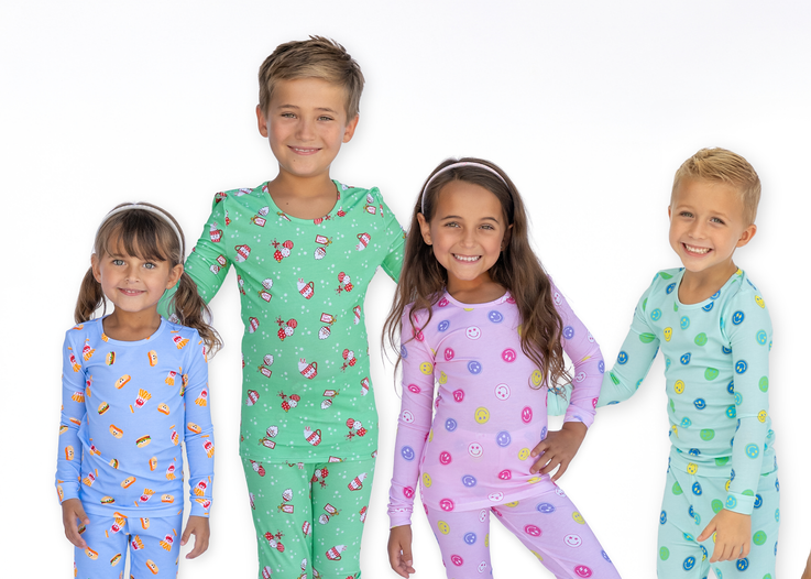 Four children wearing colorful pajamas on a white background