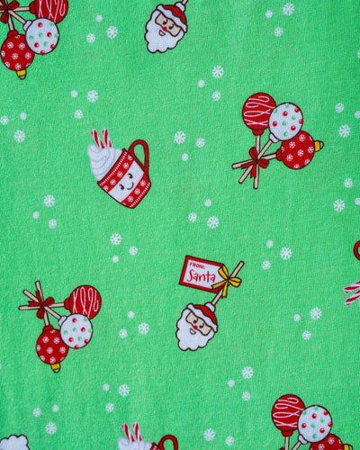 Christmas-themed fabric pattern with Santa Claus, candy canes, and lollipops on a green background.
