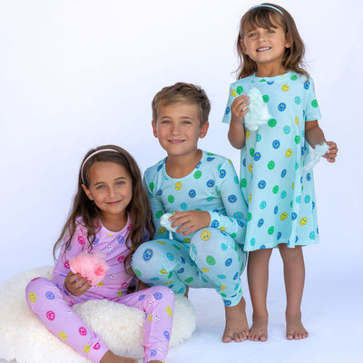 Three children wearing polka dot pajamas on a white background