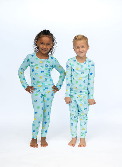 Two children wearing matching pajama sets with a blue pattern on a white background
