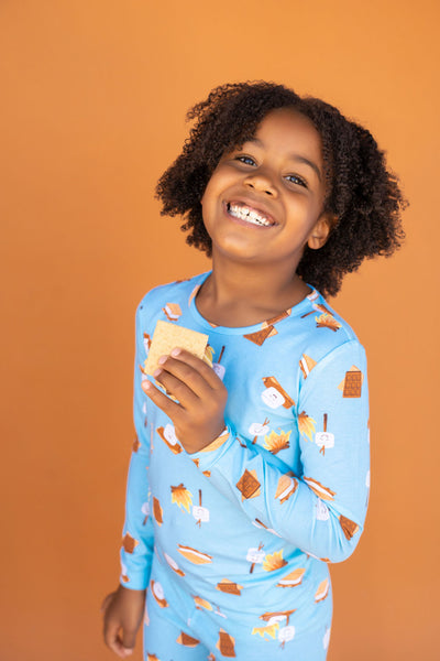 Smiling girl in PJs eating a S'more